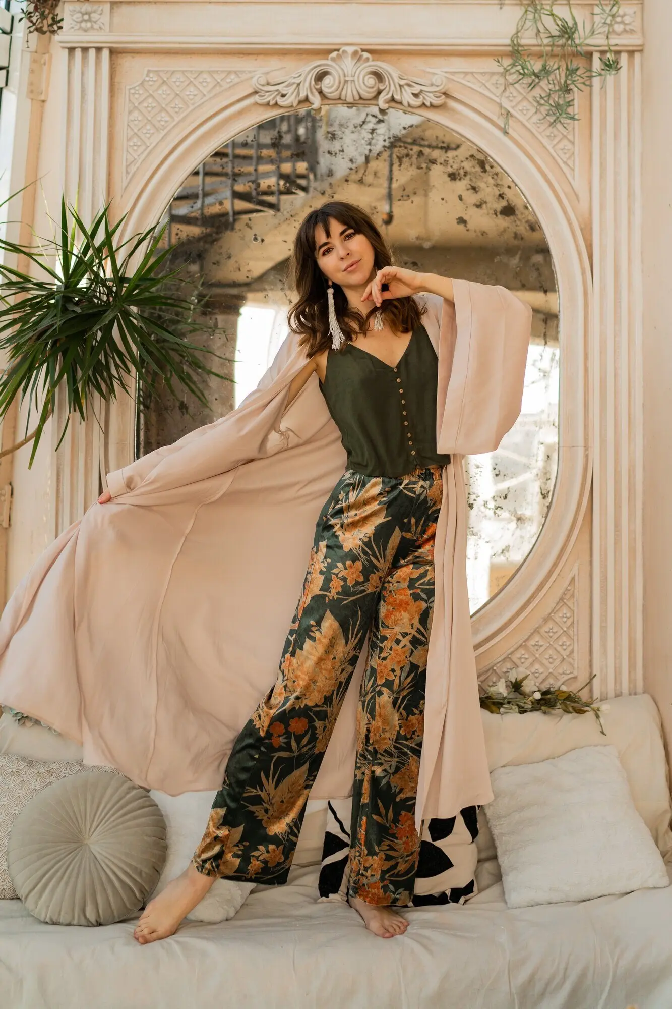 Schöne Frau in eleganter Damenbekleidung posiert in einem stilvollen bohemischen Interieur.